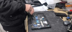 Computer technician repairing laptop to protect against ransomware attacks